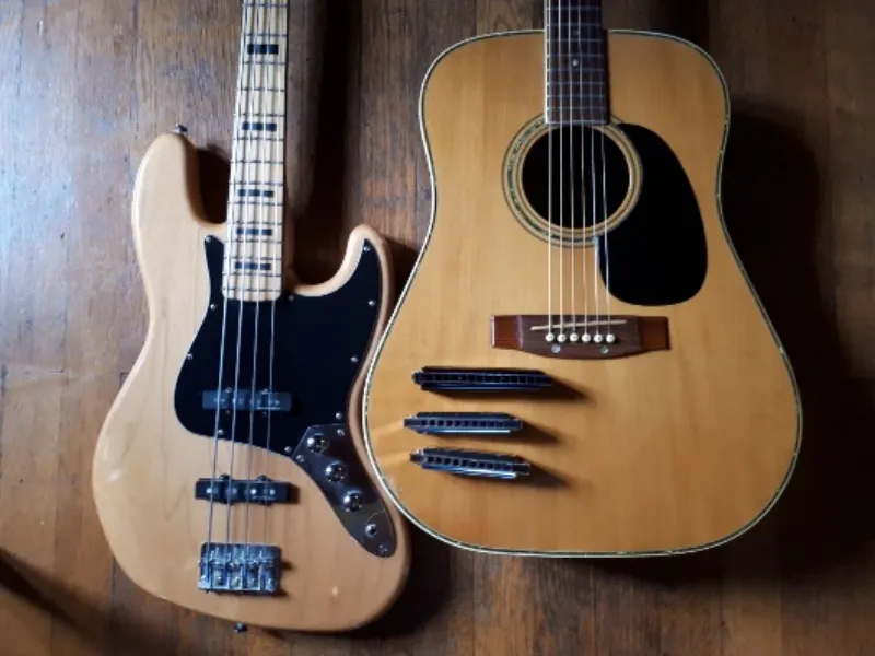 Une basse et une guitare posées contre un mur